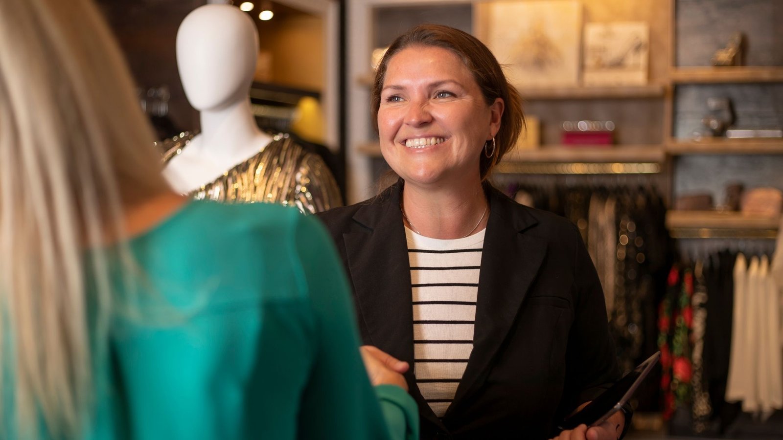 Retail store owner smiling at customer
